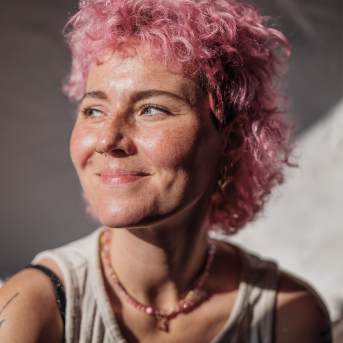 Woman with pink hair smiling